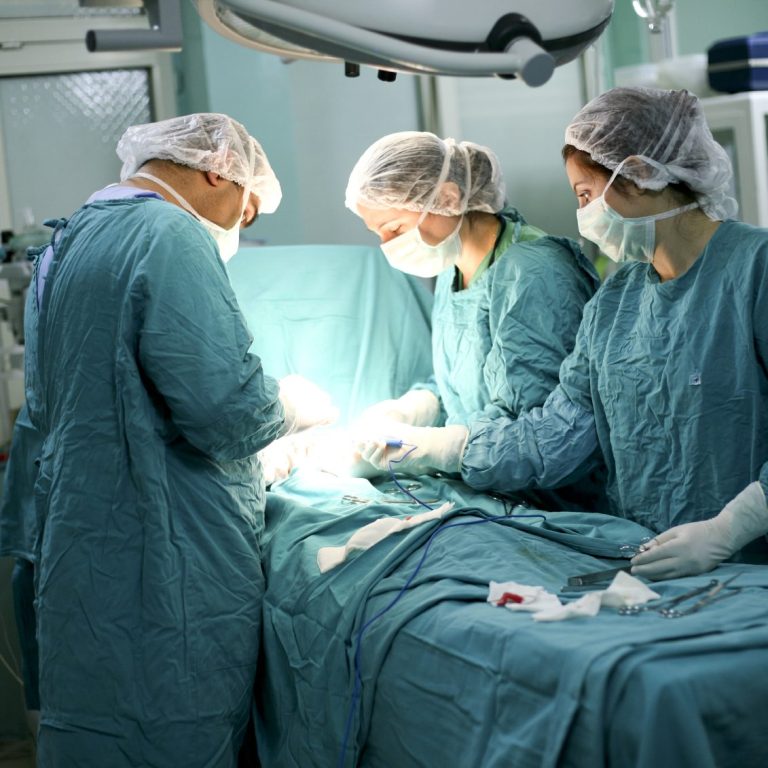 Medical team performing surgery in a sterile operating room.